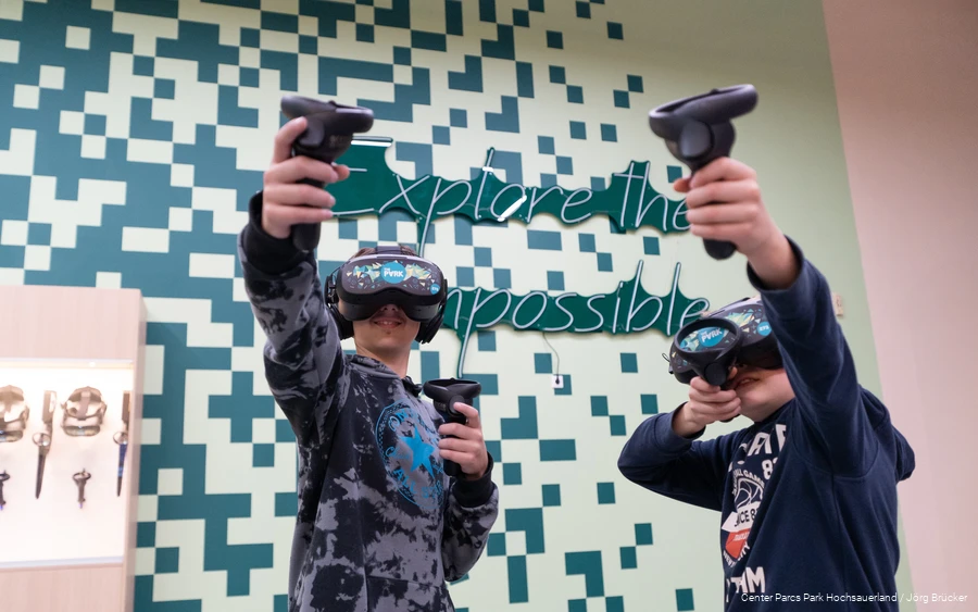 Zwei Jungen mit VR-Brillen spielen ein Spiel in der Virtual Reality Experience des Center Parcs Park Hochsauerland.