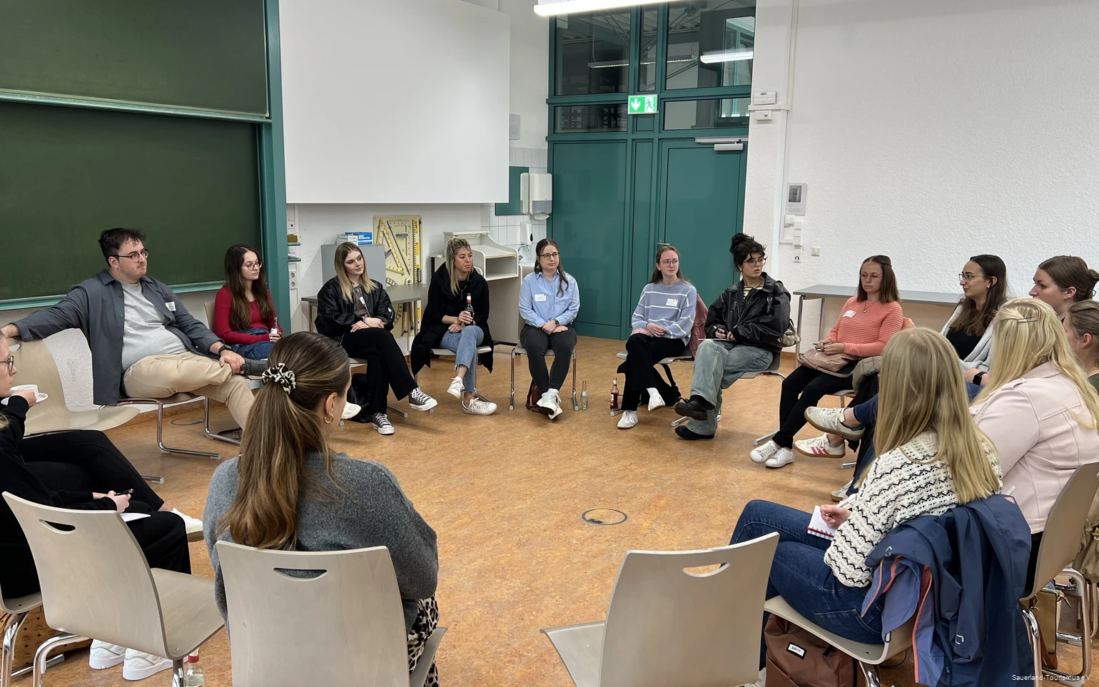 Teilnehmende einer Session des Tourismus-Barcamps sitzen im Stuhlkreis und tauschen sich aus.