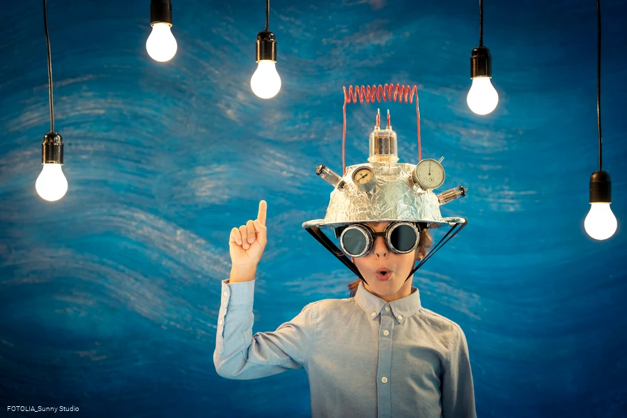 Junge mit  Helm und Glühbirne